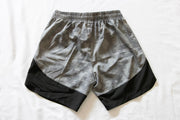 Back of gray and black mens shorts on a white background