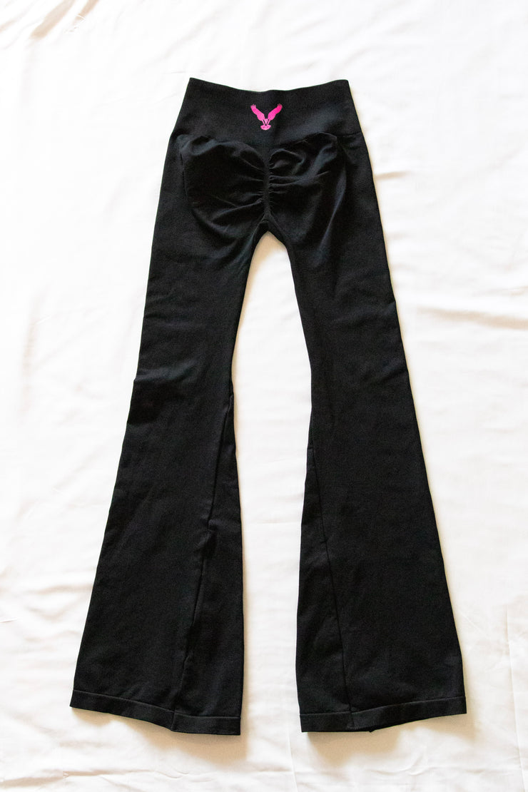 This image displays a pair of stylish "Flirty Flair Pants" for women. The pants are crafted in a sleek black color and feature a flared design that extends from the knee down, offering a chic and flowing silhouette.