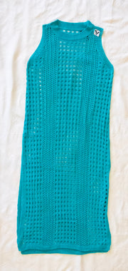 back of teal crochet dress / bathing suit cover on a white textured 