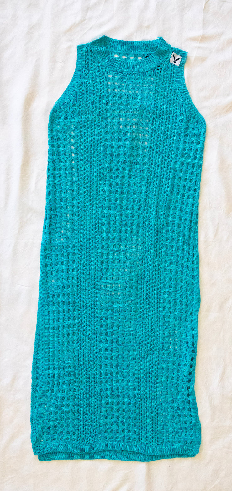 back of teal crochet dress / bathing suit cover on a white textured 