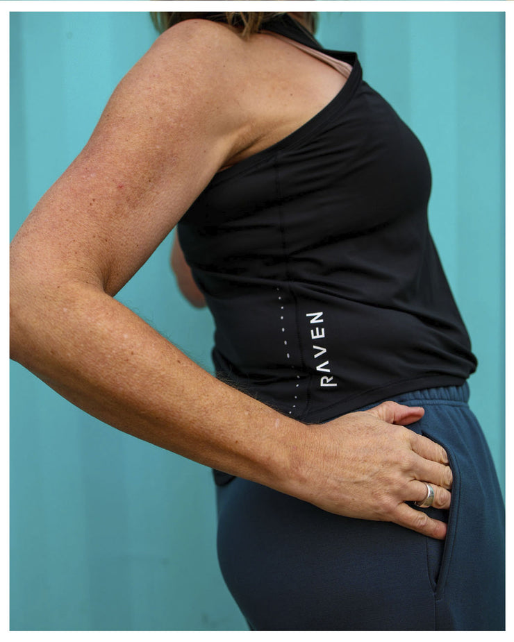 A person wearing a black tank top with the brand name &
